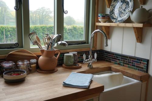 um balcão de cozinha com um lavatório e uma janela em Steam and Stars Luxury Glamping em Williton