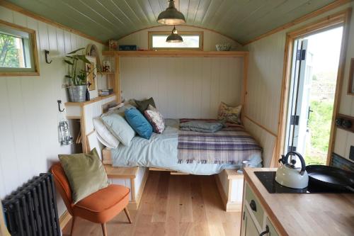 um pequeno quarto com uma cama numa pequena casa em Steam and Stars Luxury Glamping em Williton