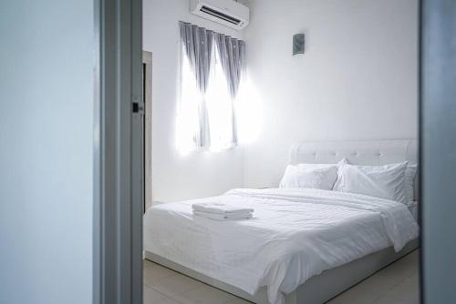 a bedroom with a white bed with a window at Jovial Modern Stylish Townhouse 8pax - BM Icon City in Bukit Mertajam