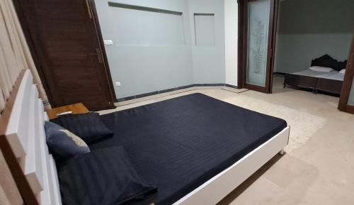 1 dormitorio con 1 cama negra en una habitación en The Guest House Islamabad, en Islamabad