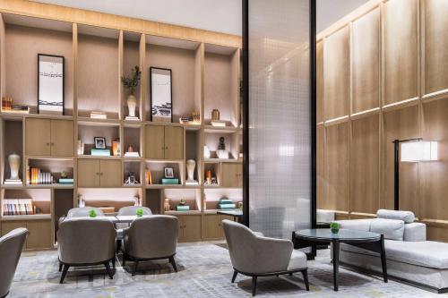 a waiting room with a table and chairs and shelves at Chengdu Marriott Hotel Financial Centre in Chengdu