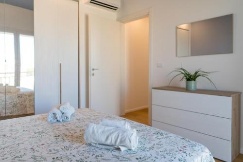 una camera da letto con un letto e asciugamani di Siracusa Bright Apartment x4 with Balcony a Siracusa