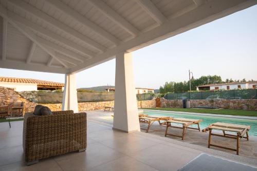 a patio with a couch and a swimming pool at Capannizza Villas in Budoni