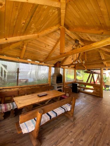 Cette grande chambre en bois dispose d'une table et d'une cheminée. dans l'établissement Mountain escape in Carpathian, à Malaia