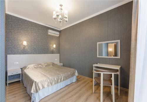 a bedroom with a bed and a table and a chandelier at Agata sunrise apartment in Megali Ammos