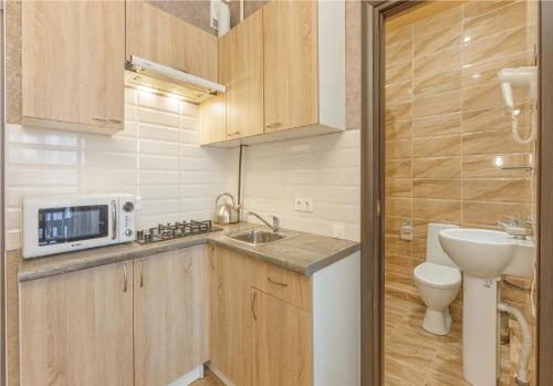 eine kleine Küche mit einer Spüle und einer Mikrowelle in der Unterkunft Agata sunrise apartment in Megali Ammos