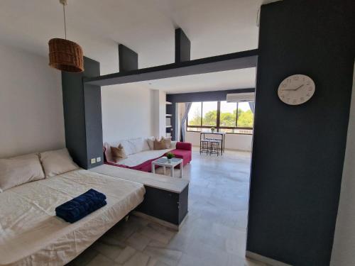 a bedroom with a bed and a clock on the wall at Apartamentos Vistahermosa in El Puerto de Santa María