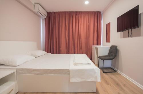 a hotel room with a bed and a chair at Pensiunea Riviera in Costinesti