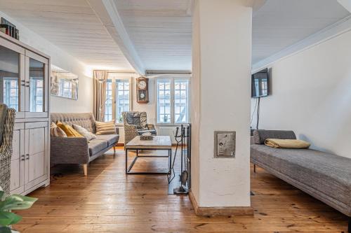ein Wohnzimmer mit einem Sofa und einem Tisch in der Unterkunft fewo1846 - Kaete-Lassen-Huus - uriges Häuschen auf 3 Ebenen mit Dachterrasse am Hafen in Flensburg