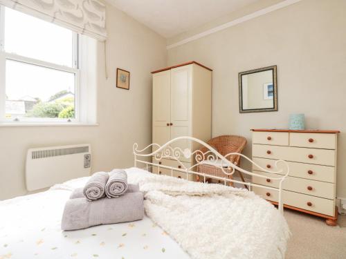 a bedroom with a white bed with towels on it at Driftwood in Dartmouth