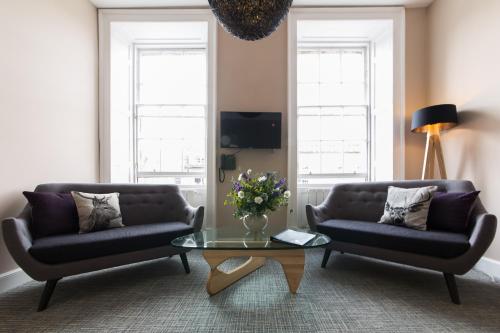 uma sala de estar com dois sofás e uma mesa de centro em The Spires Serviced Apartments Edinburgh em Edinburgo