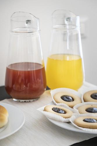 a table with a plate of donuts and two bottles of juice at B&B Vicere Speciale in Noto