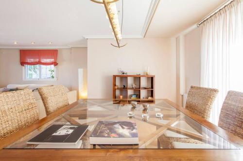 a living room with a glass table and chairs at Casa en Valencia, piscina, cerca de golf, playas, moto Gp in Valencia