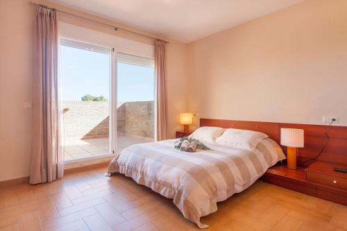 ein Schlafzimmer mit einem Bett und einem großen Fenster in der Unterkunft Casa en Valencia, cerca de golf, playas, moto Gp in Valencia