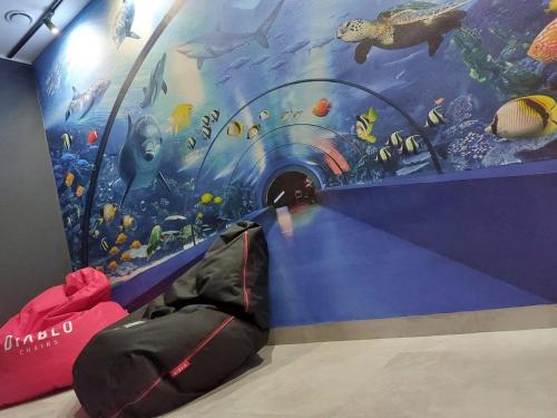 a room with a tunnel with a painting of an aquarium at Apartamenty i Pokoje Złote Piaski in Jastrzębia Góra