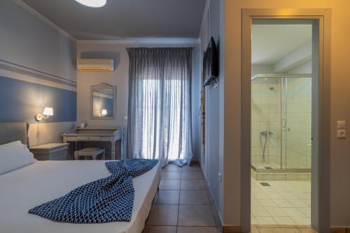 a bedroom with a bed and a bathroom with a shower at Pelagos Apartments in Skala