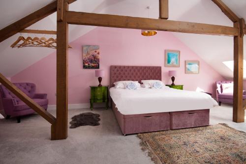 - une chambre mansardée avec un grand lit dans l'établissement Walltown Farm Cottage, à Brampton