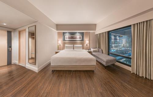 a hotel room with a bed and a window at Seda Central Bloc Cebu in Cebu City