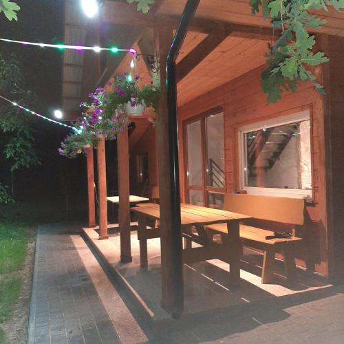 a picnic table outside of a cabin at night at Roztocze 3 kroki od sosny in Zamość
