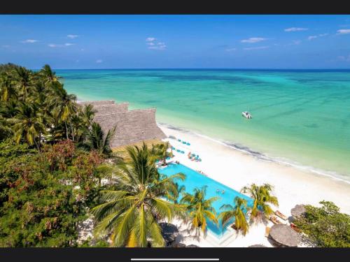 eine Luftansicht auf einen Strand mit einem Pool in der Unterkunft NDAME Paje Hotel in Paje