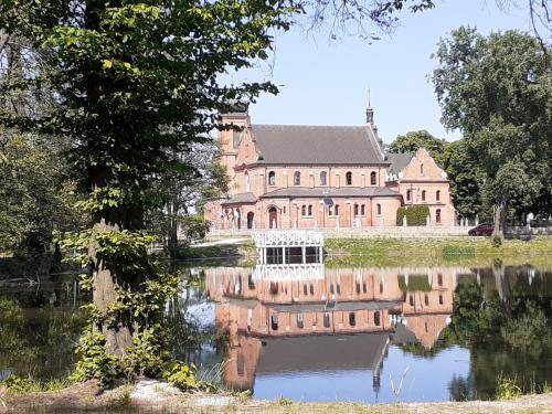 een groot huis met een meer ervoor bij Złotopolska Sielanka 