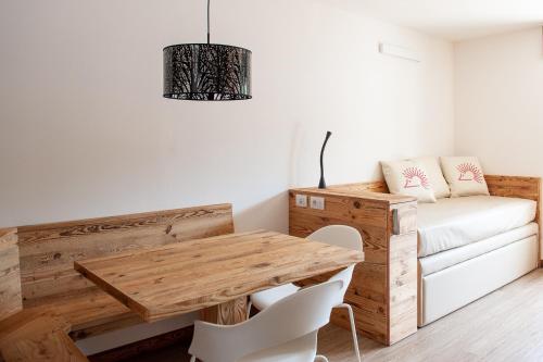a room with a wooden table and a couch at Residence Lastei in San Martino di Castrozza