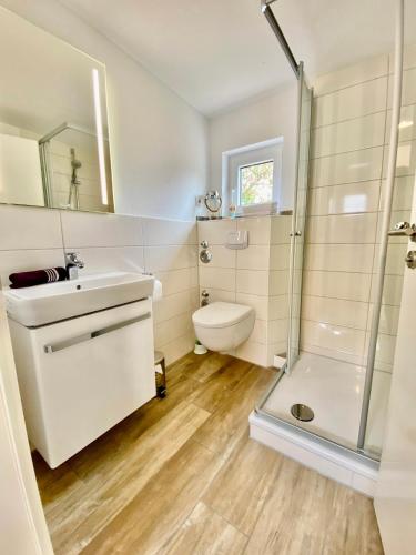 a bathroom with a shower and a sink and a toilet at Am Oland 11 Bungalow in Büsum