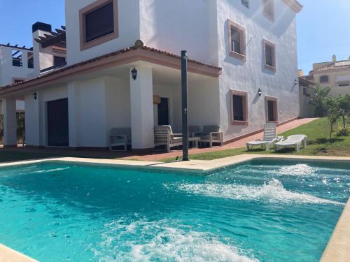 una piscina frente a una casa en Chalet Hato Verde Golf, en Guillena
