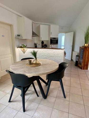 a kitchen with a table and two chairs and a counter at Bungalowpark Het Verscholen Dorp in Harderwijk