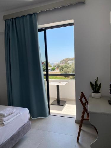 a bedroom with a sliding glass door to a balcony at Ikaros Studios in Faliraki