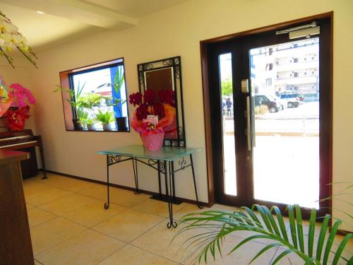 a room with a table with flowers and a mirror at Ao-Ao-Hotel - Vacation STAY 32070v in Nago