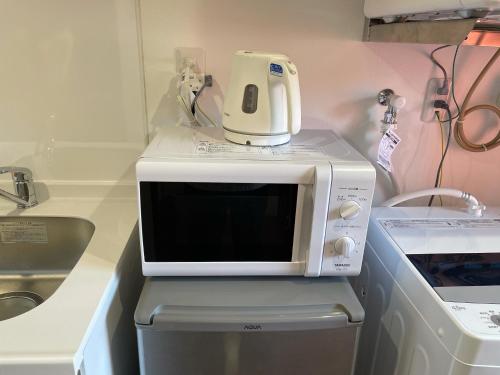 a microwave oven sitting on top of a dishwasher at Ao-Ao-Hotel - Vacation STAY 32070v in Nago