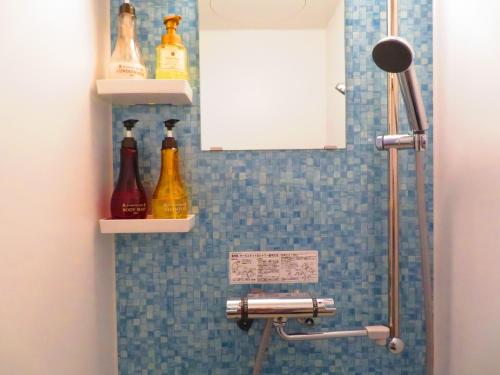een badkamer met een douche en flessen aan de muur bij Ao-Ao-Hotel - Vacation STAY 32070v in Nago