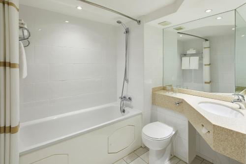 uma casa de banho com uma banheira, um WC e um lavatório. em The Aberdeen Dyce Hotel em Dyce