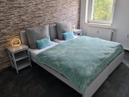 1 dormitorio con cama, sofá y pared de ladrillo en Theox No 10 für 6 Personen, en Duisburg