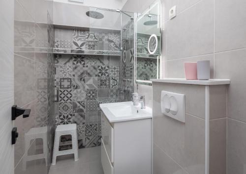 ein weißes Bad mit einem Waschbecken und einer Dusche in der Unterkunft Apartments with a parking space Stanici, Omis - 2819 in Omiš