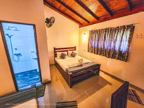 a bedroom with a bed and a large window at Birds Paradise Inn in Udawalawe