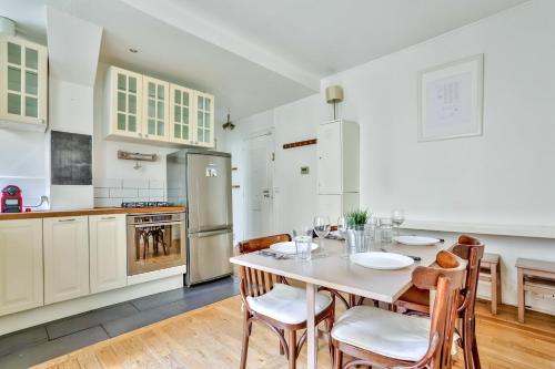 une cuisine avec une table et des chaises dans une pièce dans l'établissement Appartement Quartier Pigalle Free Netflix, à Paris