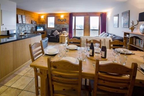 une salle à manger et un salon avec une table et des chaises dans l'établissement Toulouse - 3 bedroom apt close to the slopes with log fire, à Sainte-Foy-Tarentaise