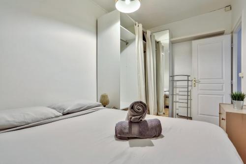 - une chambre dotée d'un lit blanc avec une statue dans l'établissement Appartement Quartier Pigalle Free Netflix, à Paris