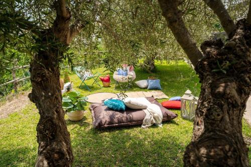 une personne assise sur une table de pique-nique sous un arbre dans l'établissement Villa Mascali Nature & Relax - Affitti Brevi Italia, à Nunziata