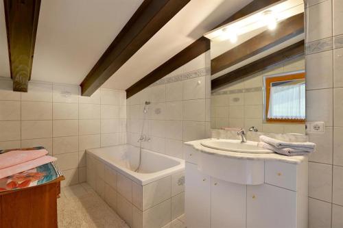 uma casa de banho com uma banheira e um lavatório e uma banheira em Haus Pöll em Prama