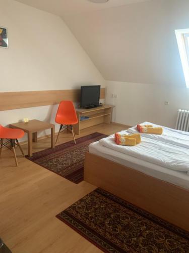1 dormitorio con 1 cama y escritorio con TV en Penzion Ludor en Strážnice