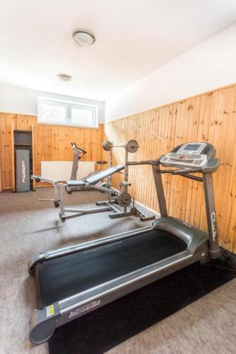 a gym with a treadmill in a room with wooden walls at Hotel Sipox in Štrba