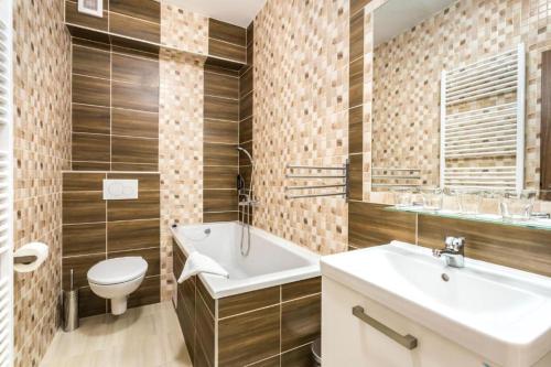 uma casa de banho com um lavatório, um WC e uma banheira em Hotel Sipox em Štrba