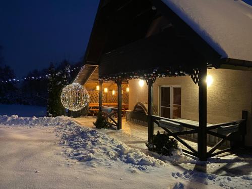 a house covered in snow at night with lights at Szmaragdowy domek in Nowy Wiśnicz