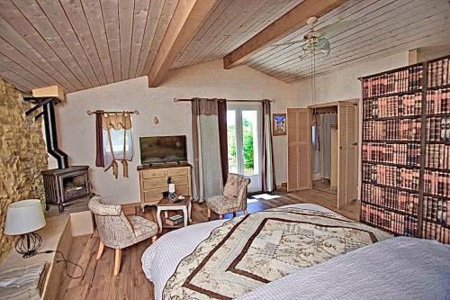 - une chambre avec un lit, une cheminée et une télévision dans l'établissement Chambres d'hôtes et Gîtes Les Restanques, à Saint-Alexandre