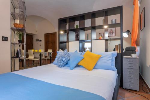 a bedroom with a large bed with blue and yellow pillows at La Casa del Polpo Giallo by Wonderful Italy in Turin