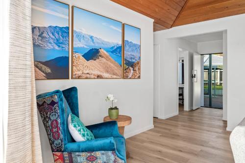 a living room with a blue chair and mountains at Family Perfect, winter getaway, secure yard, parking, mountain bikes, arcade in Rotorua