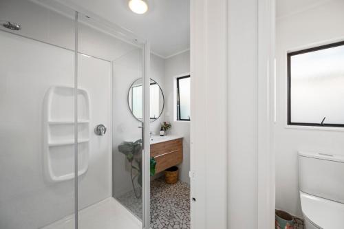 a bathroom with a glass shower and a sink at Teemos Retreat - Family and Friends, lots of space, big backyard in Rotorua